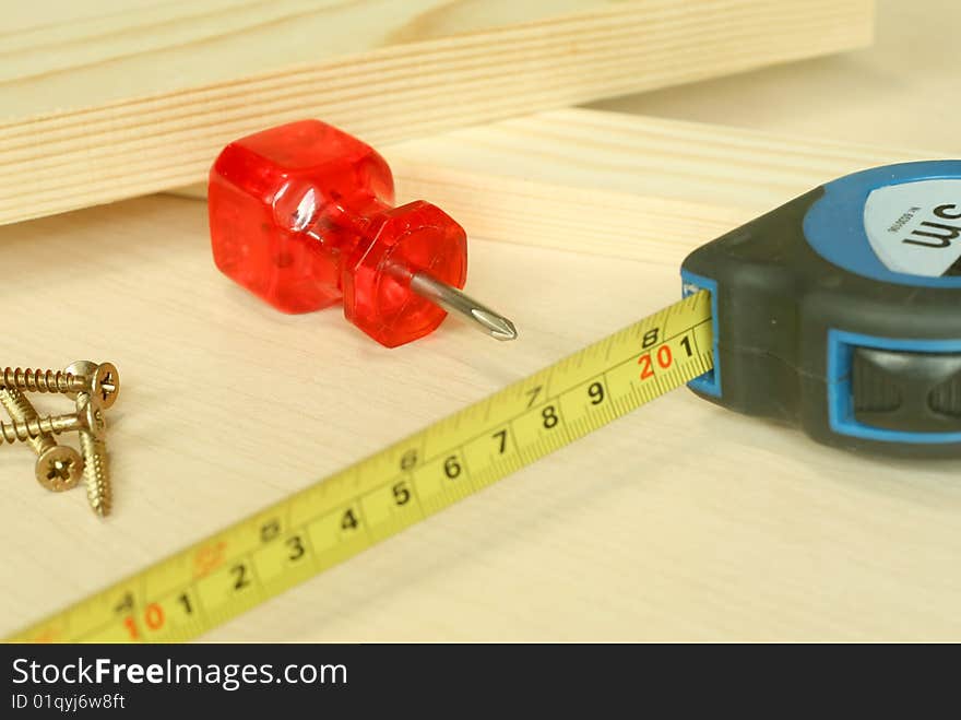 Boards, screw-driver and measuring tape. Building background