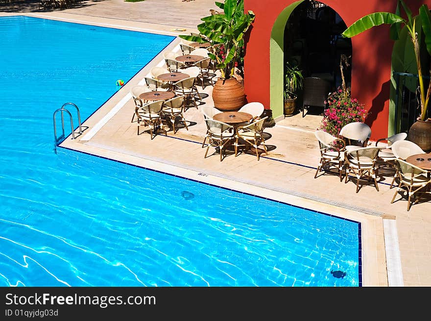 Tables and chairs near swimming pool. Tables and chairs near swimming pool