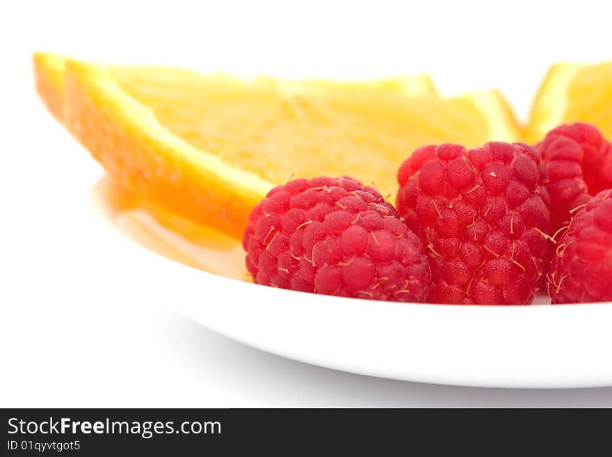 Raspberry and sliced  orange on plate. Raspberry and sliced  orange on plate