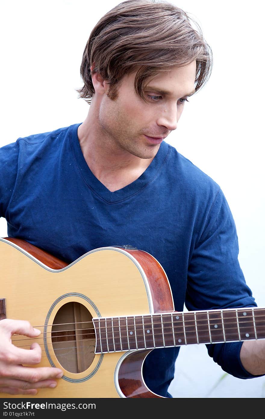 An attractive guitar player with a blue shirt and white background