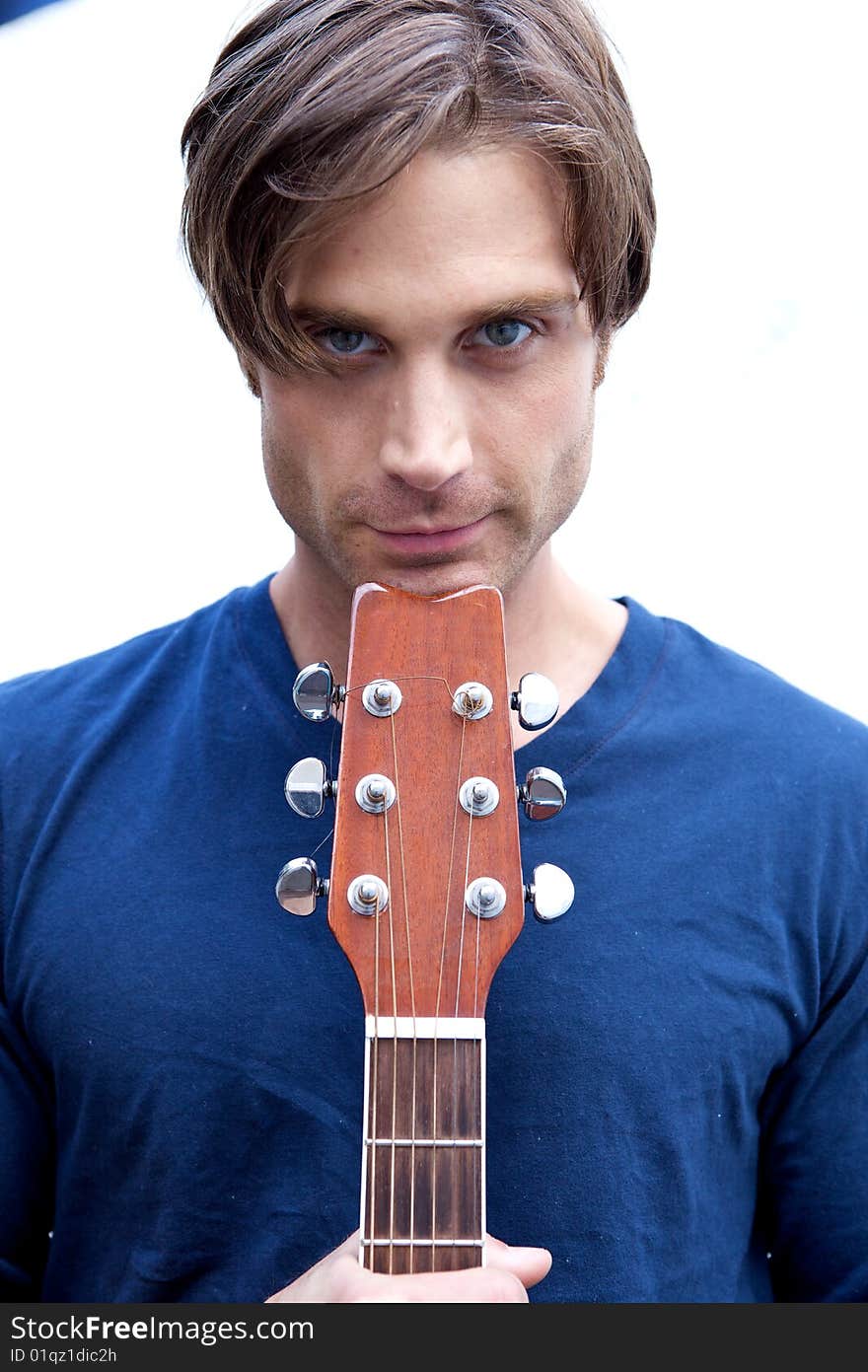 An attractive guitar player with a blue shirt and white backround