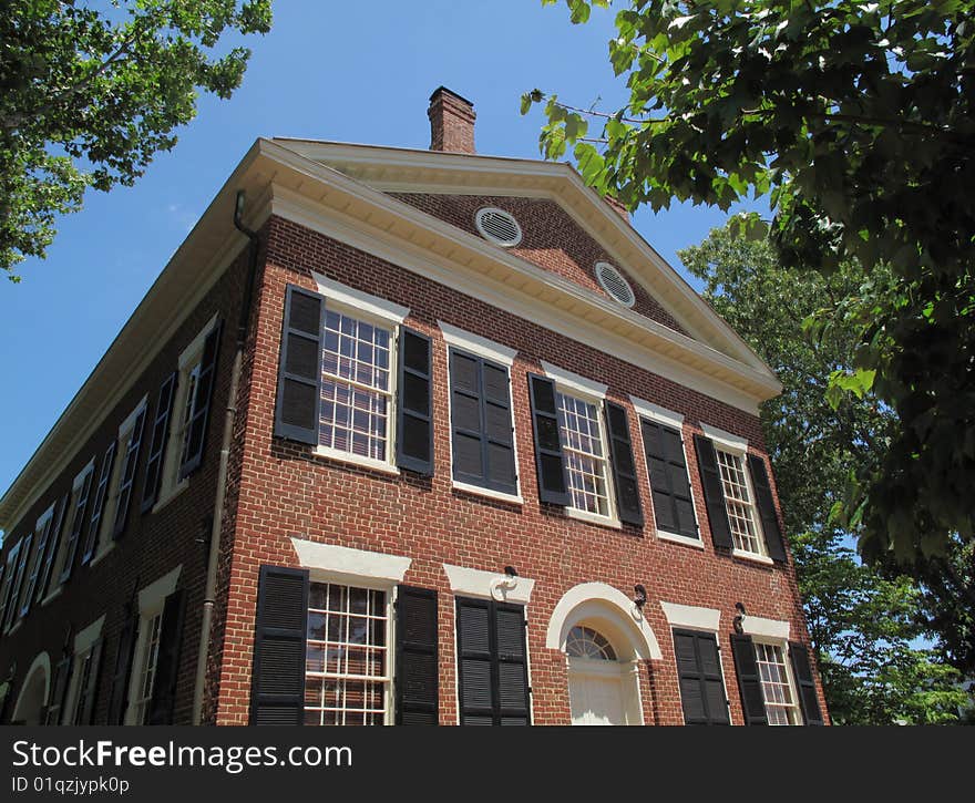 A 19th century classic American home in brick with wood shutters.