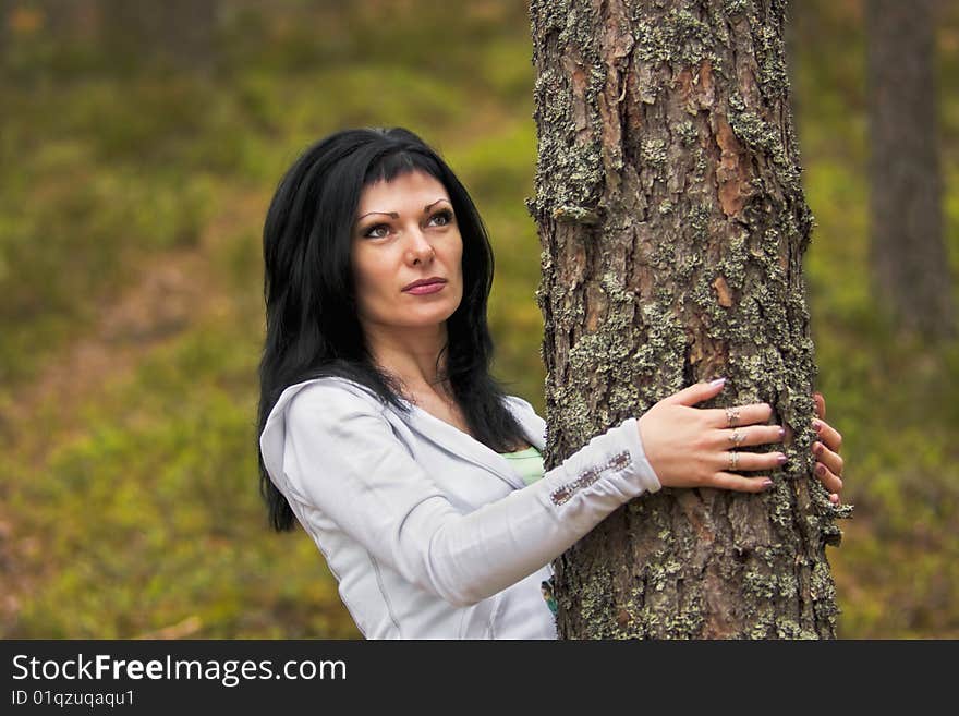 Young girl in a pine forest hugs a tree. Young girl in a pine forest hugs a tree