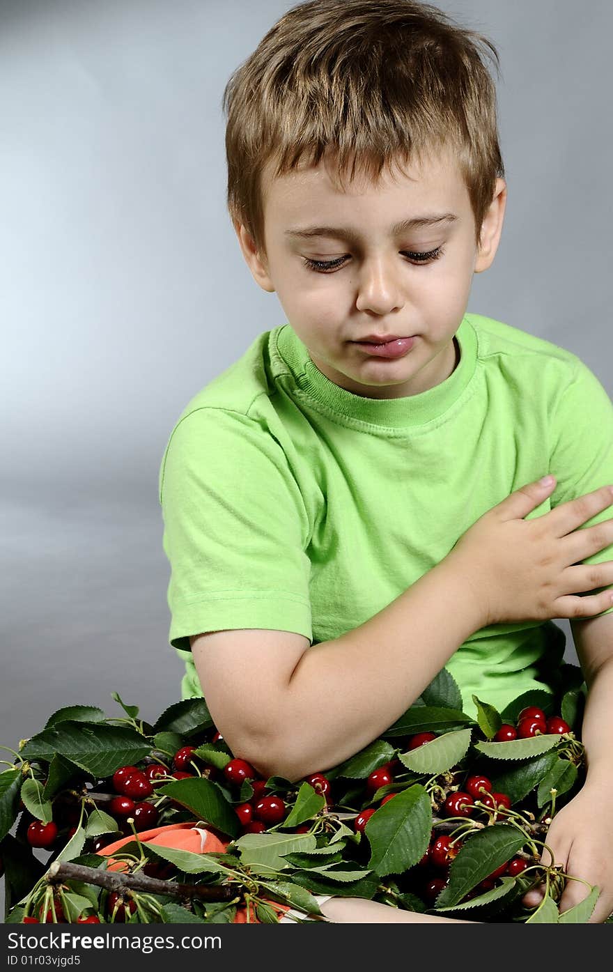 Portrait of small boy eating a lot of cherries. Portrait of small boy eating a lot of cherries