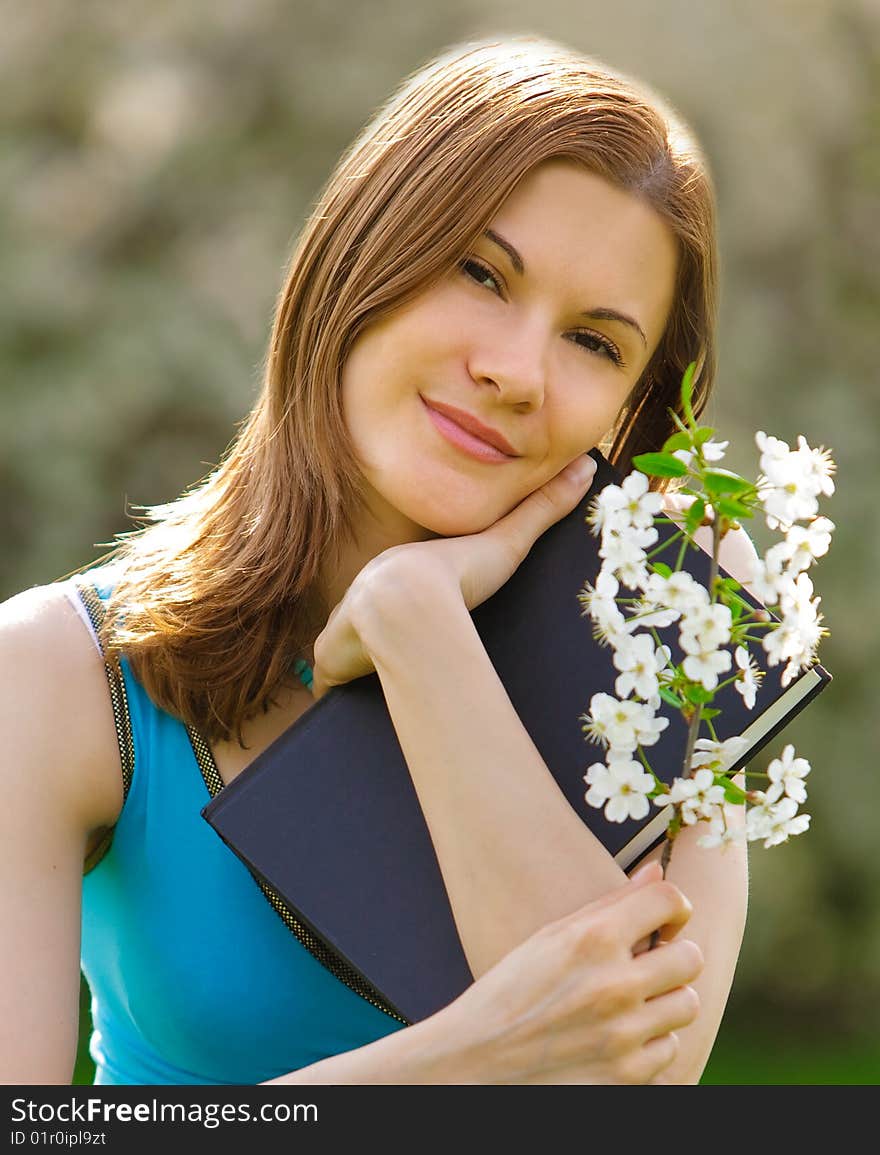 Pretty girl with a book and a flower outdoors. Pretty girl with a book and a flower outdoors