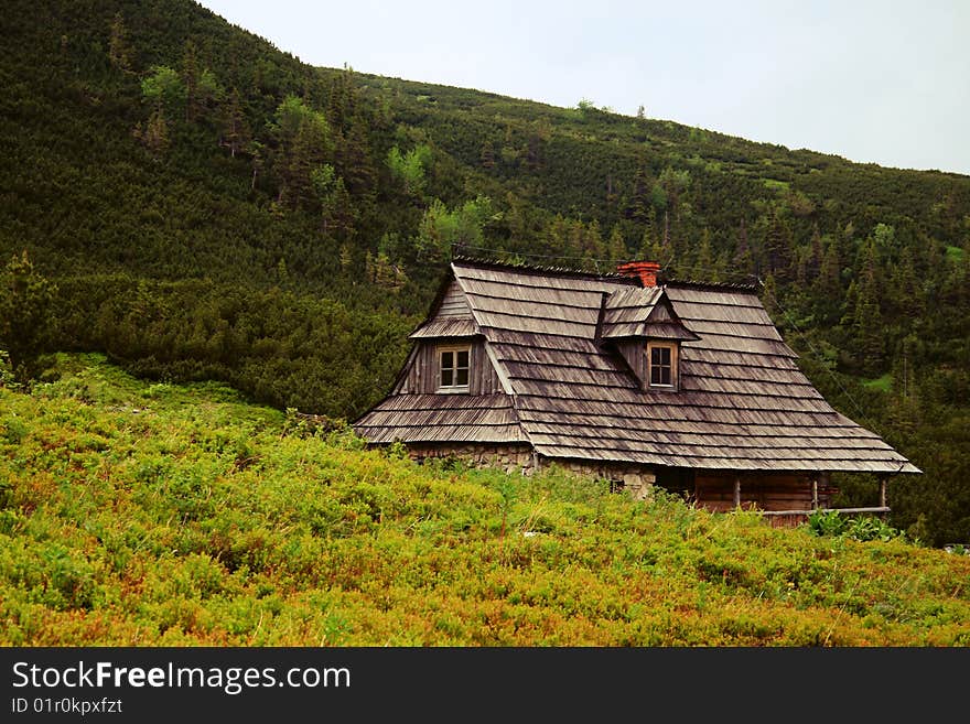 Wooden mountain hut with mountains in the background