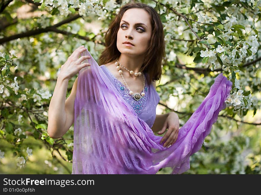 Tender girl in the garden with flowerings trees