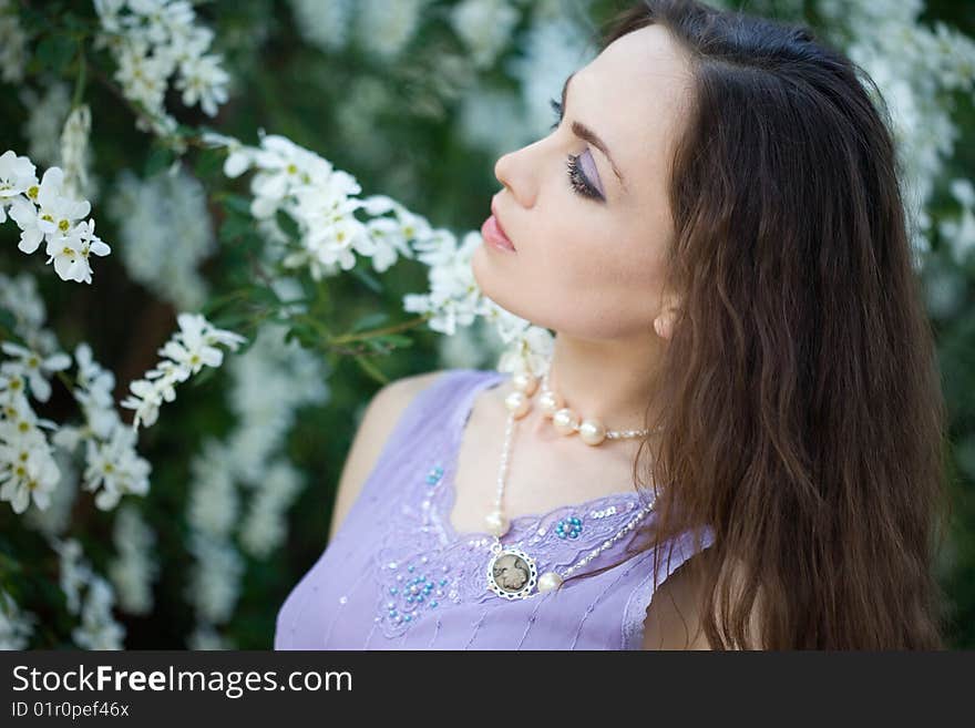 Tender girl in the garden with flowerings trees