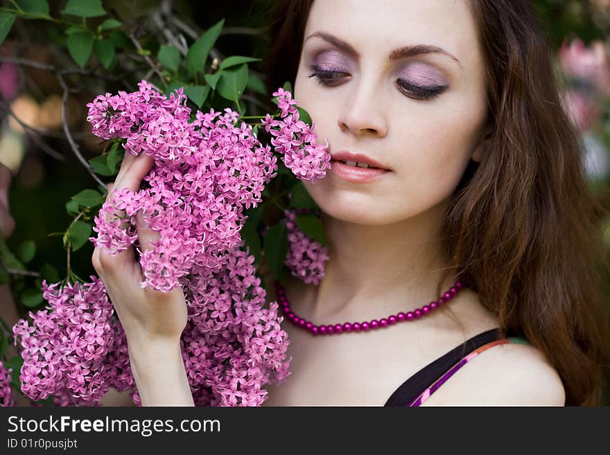 Tender girl in the garden with lilac