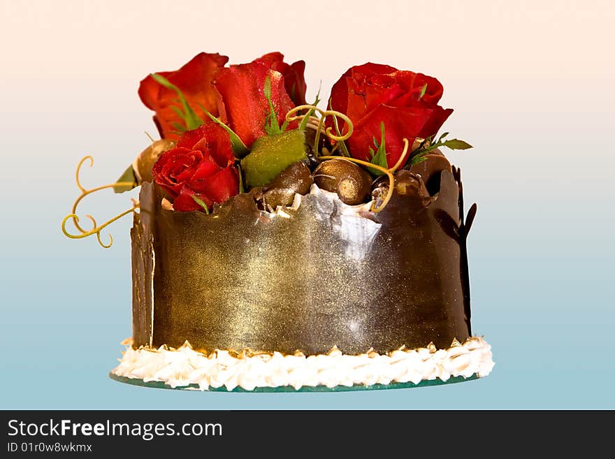 Closeup of a chocolate cake with red roses ontop.