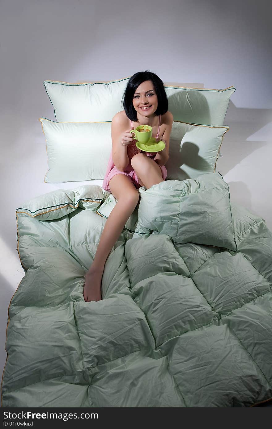 Young beautiful woman lying with down pillows and blanket. Young beautiful woman lying with down pillows and blanket