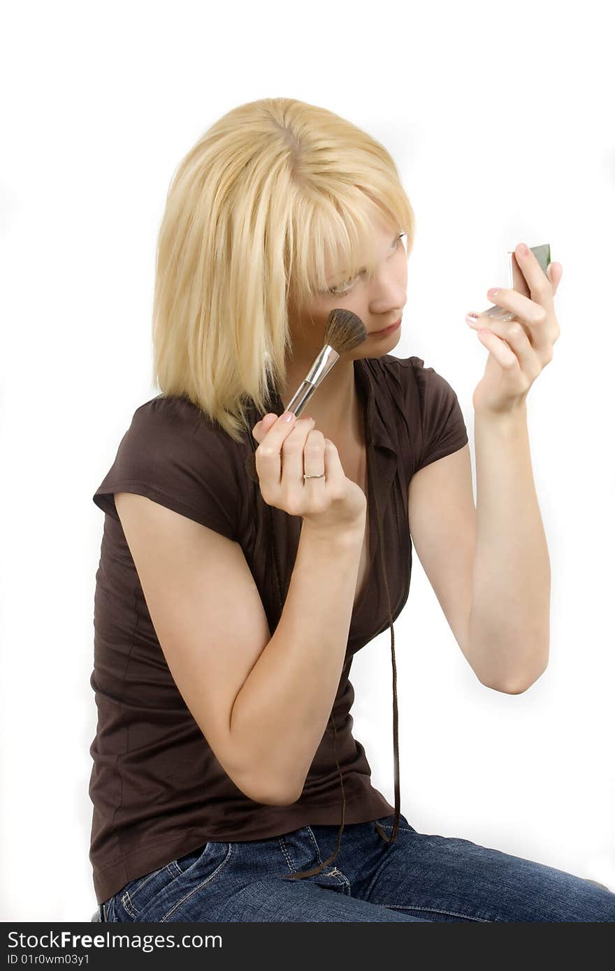 Portrait of the beautiful girl with blond hair and blue eyes on white putting on makeup. Portrait of the beautiful girl with blond hair and blue eyes on white putting on makeup