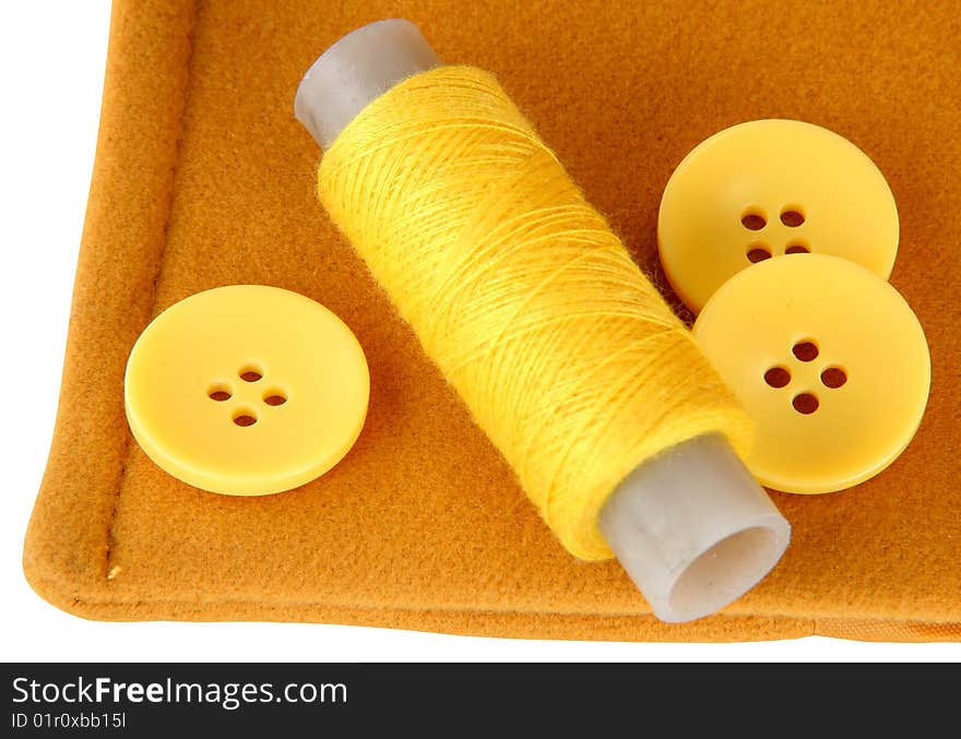 Yellow fabric of a thread and three buttons. Yellow fabric of a thread and three buttons