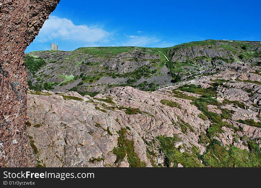 Scenic view of rock formations in countryside with blue sky background. Scenic view of rock formations in countryside with blue sky background.