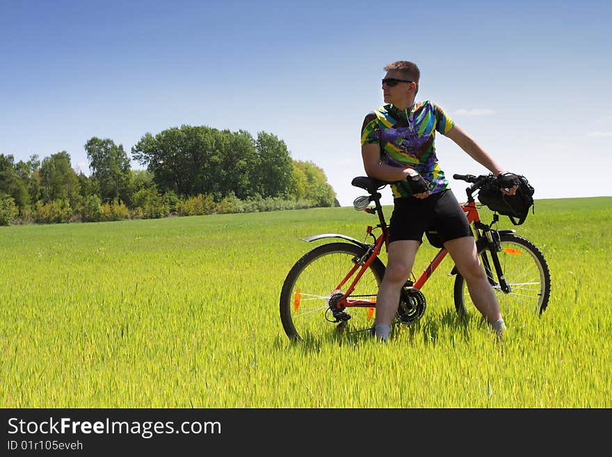 Young Biker tourist relaxation in green field. Young Biker tourist relaxation in green field