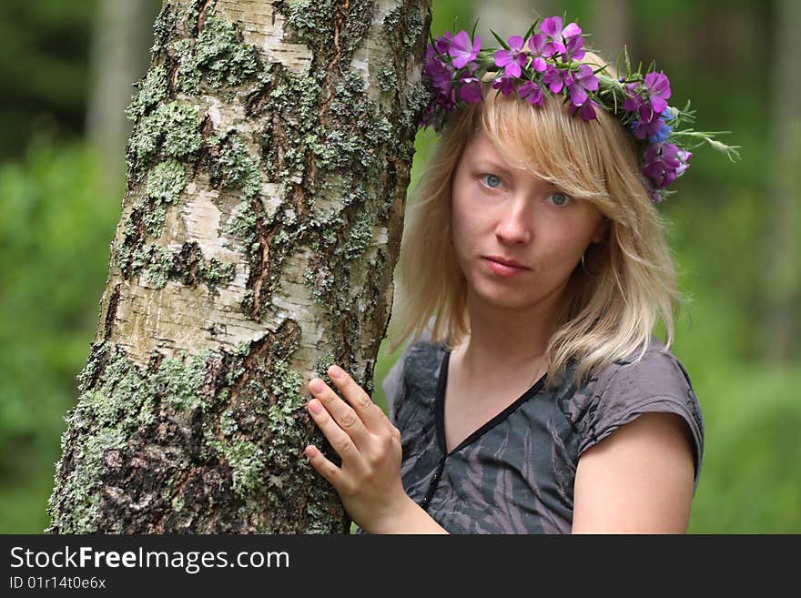 The blonde looks from behind the tree. The blonde looks from behind the tree