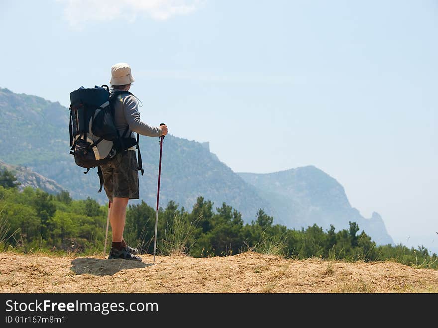 Hiker on a peak enjoys a landscape