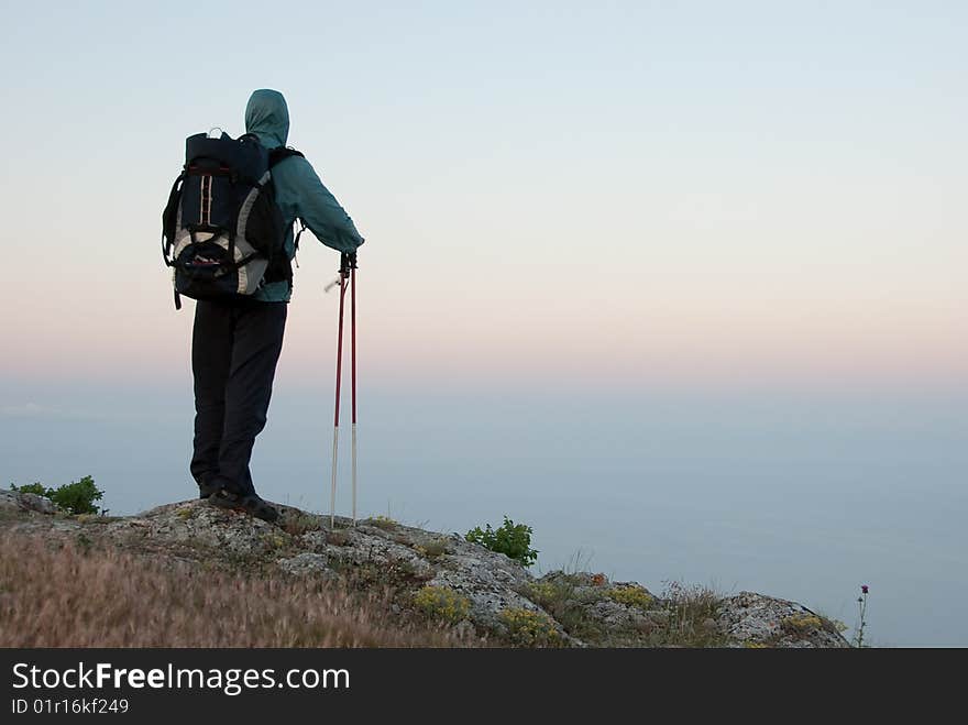 Hiker on a peak enjoys sea landscape