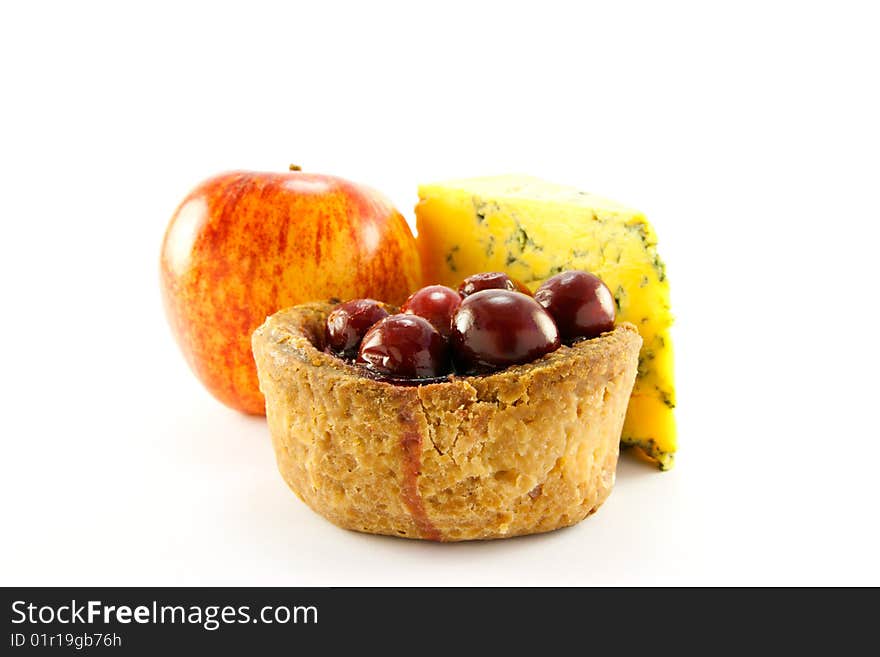 Pork pie with cranberry top with a red apple and slice of blue cheese with clipping path on a white background. Pork pie with cranberry top with a red apple and slice of blue cheese with clipping path on a white background