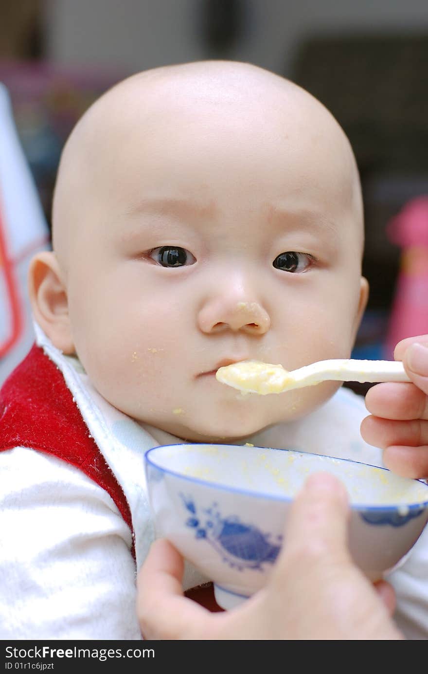 Baby with a spoon in a mouth. Baby with a spoon in a mouth