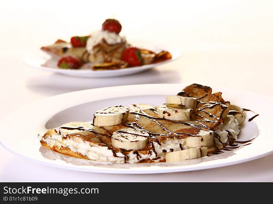 A dessert plate witn pancakes and strawberry