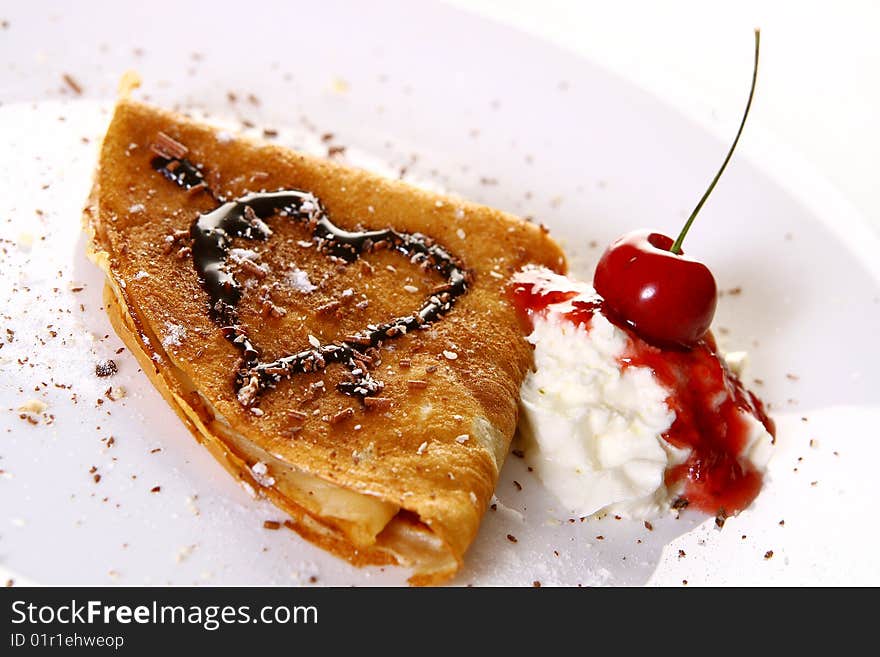 A dessert plate witn pancakes and strawberry