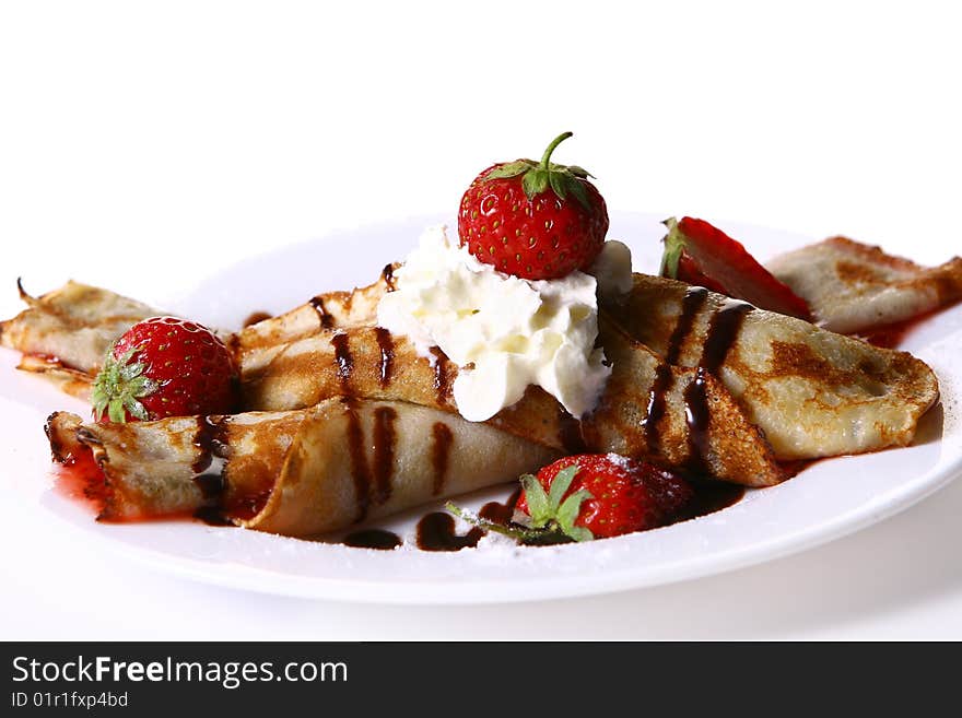 A dessert plate witn pancakes and strawberry