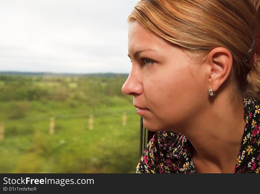 Young woman looking in the window of a train