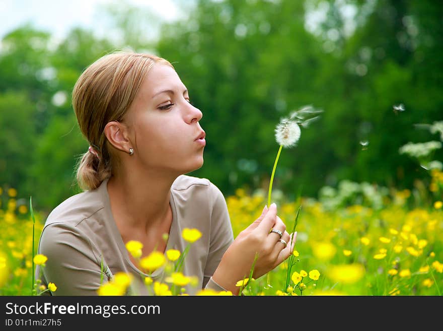 The girl blows on a dandelion