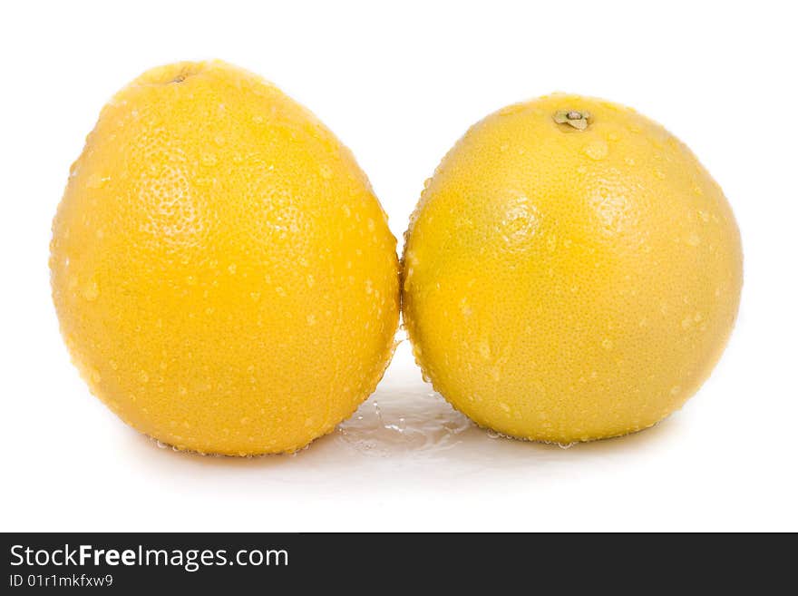 Two grapefruit with water droplets isolated on white background