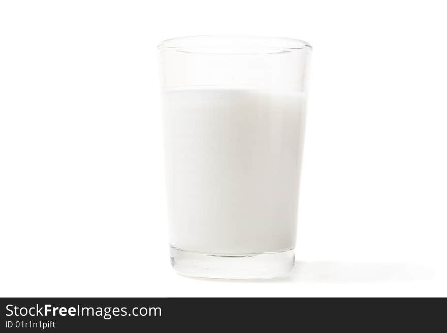 Full glass of milk on white ground