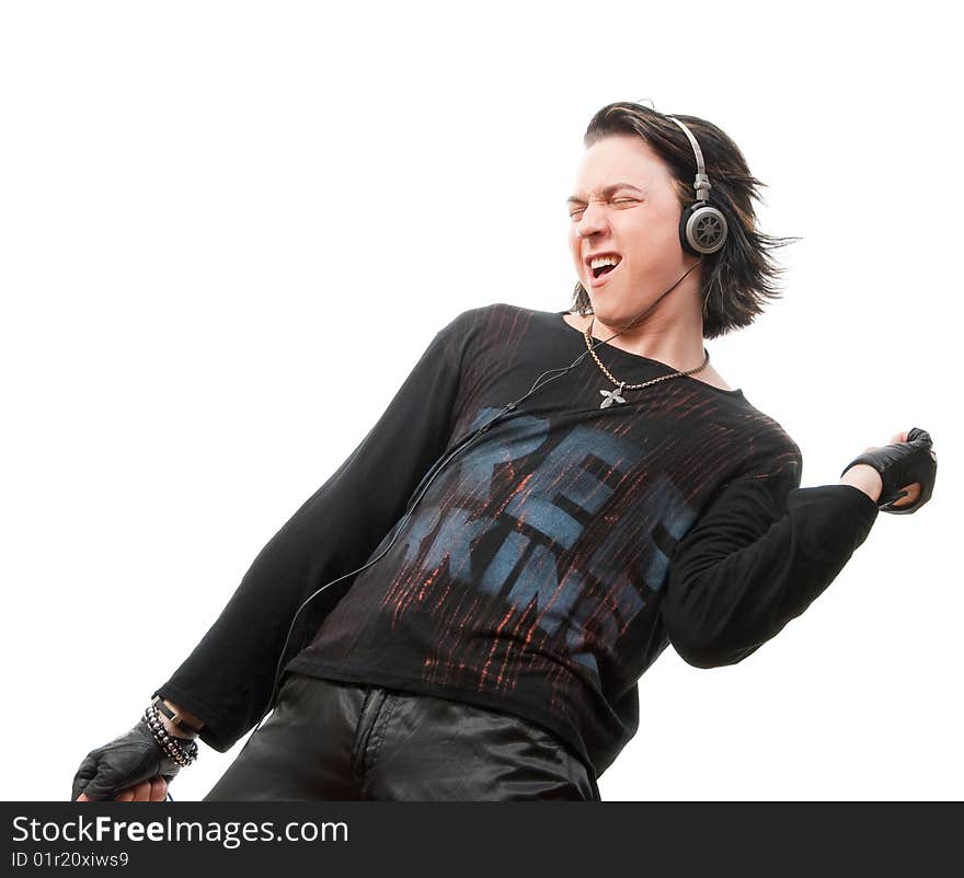 Young man listens to music in ear-phones. Isolated over white in studio