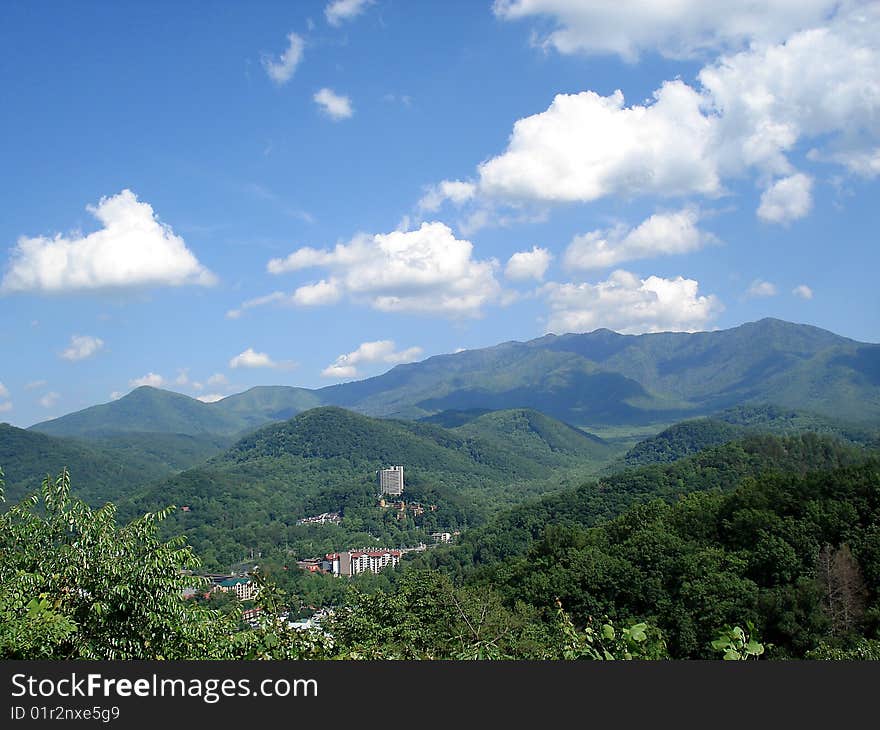 Mountain city between green mountains and under white clouds