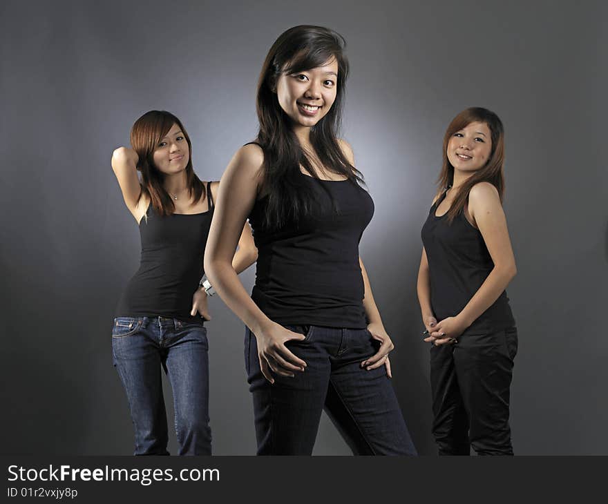 Three Beautiful Young Asian Women Dressed Casually In Black Tops. Three Beautiful Young Asian Women Dressed Casually In Black Tops.