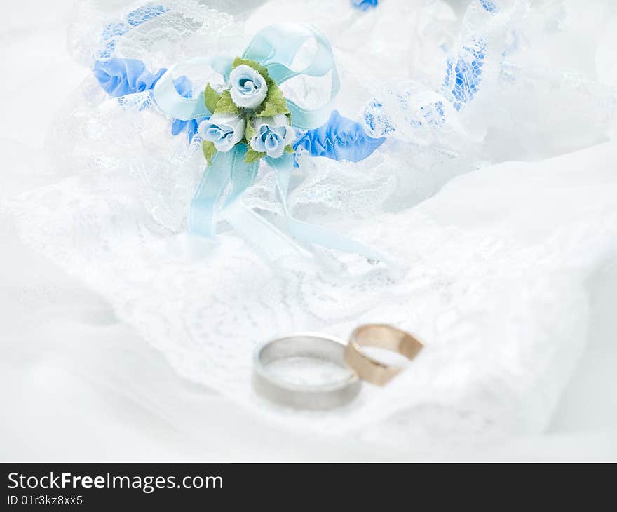 Closeup of wedding rings on a white veil