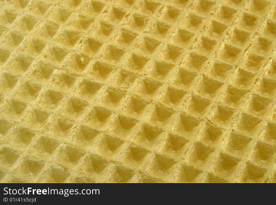 Yellow waffle macro background textured top surface. Yellow waffle macro background textured top surface