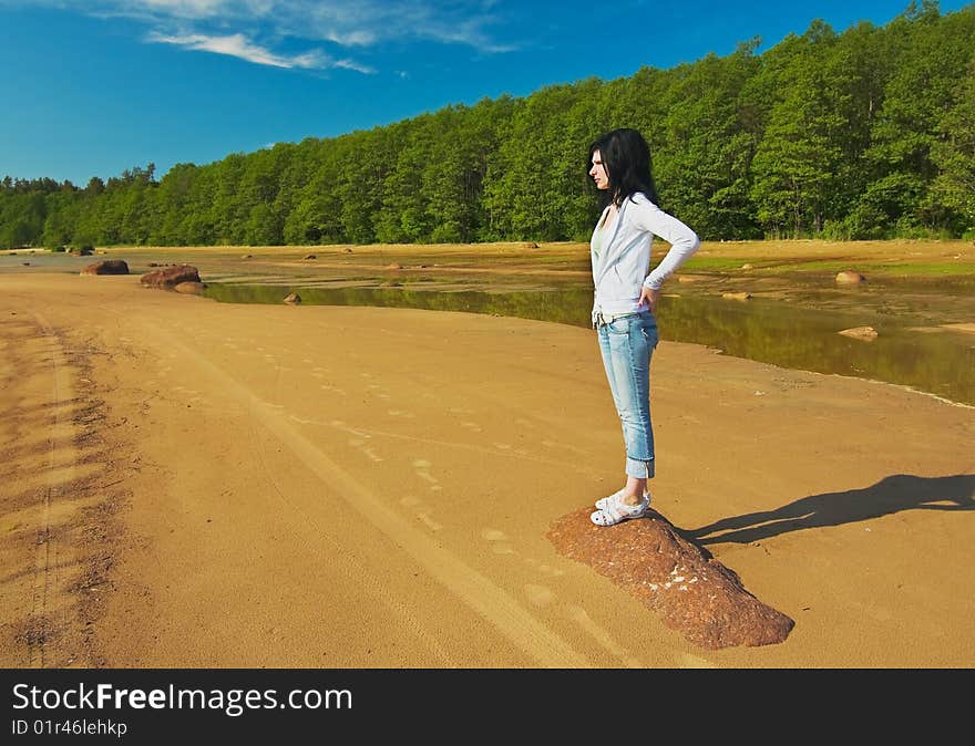 Young girl on the shore of the Gulf is looking into the distance