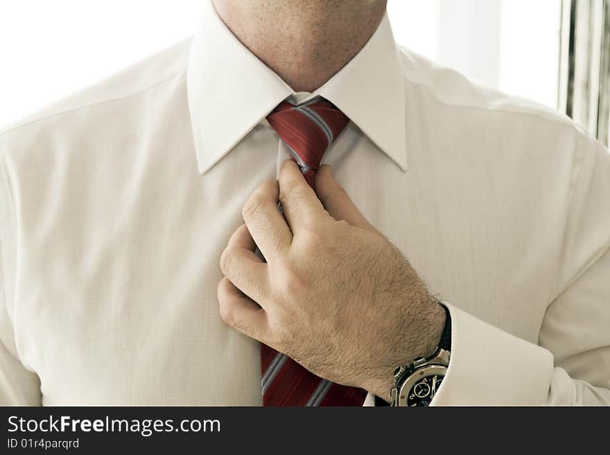 Businessman adjusting tie