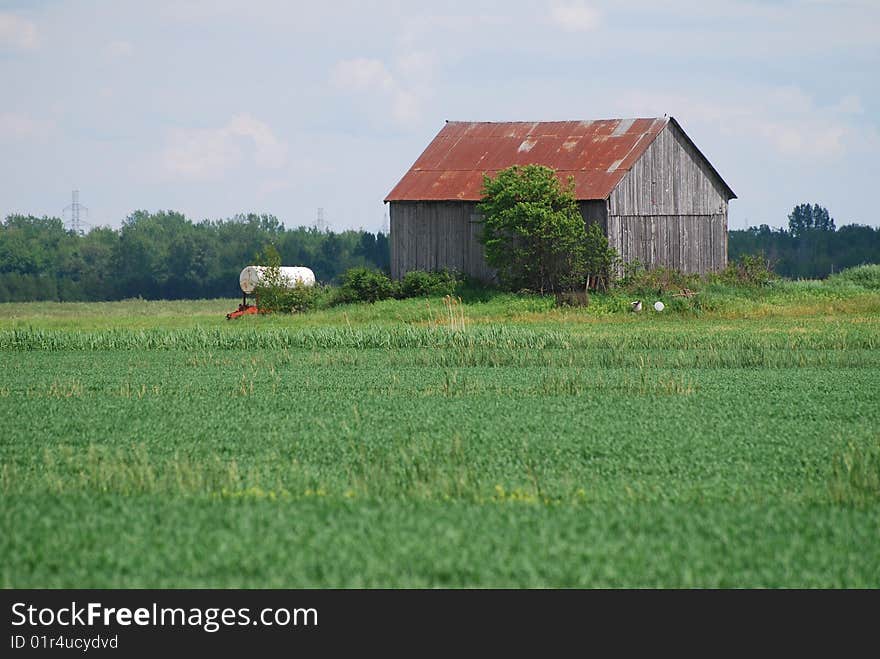 Old barn with water tank in the middle field. Old barn with water tank in the middle field