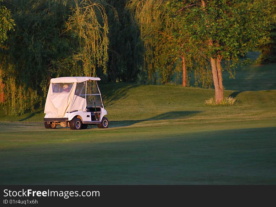 Man driving a golf cart on a nice sunny day. Man driving a golf cart on a nice sunny day