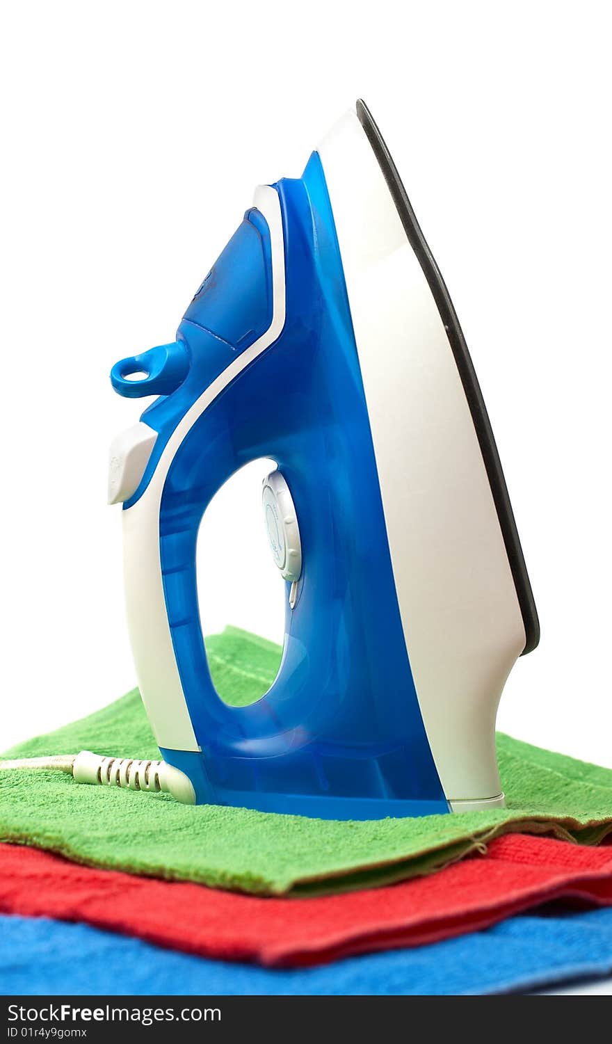 Flat smoothing iron staying on coloured bath towels