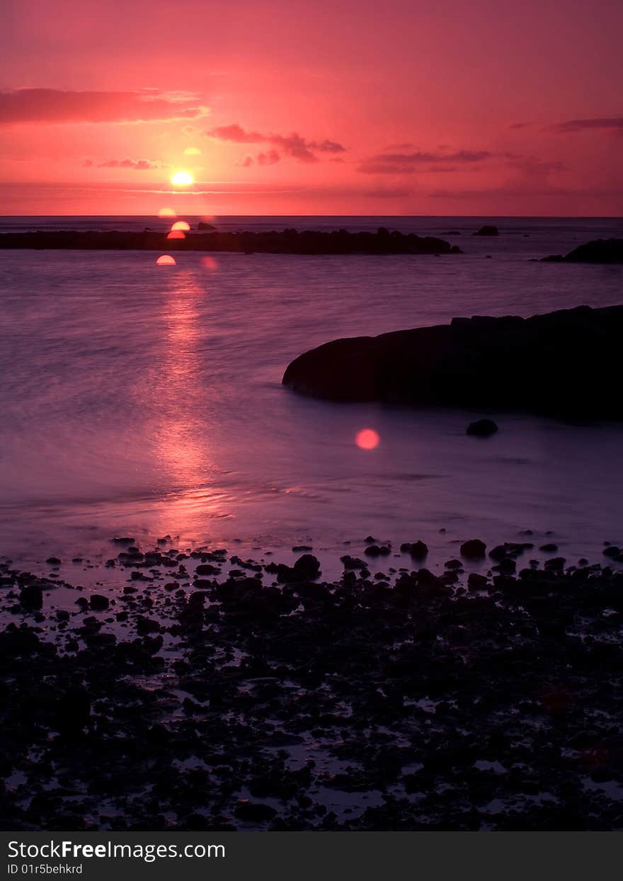 Sunset in Mauritius by a rocky beach