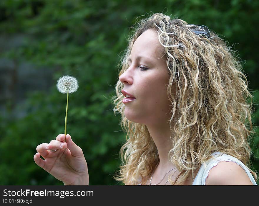 Curly girl blow dandelion