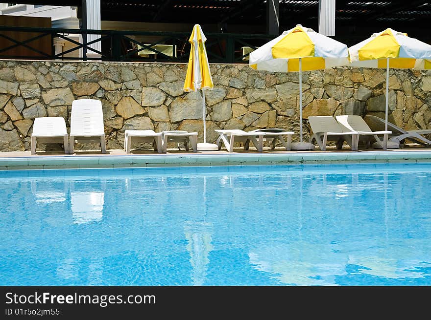 Sunbeds and umbrellas near resort's pool. Sunbeds and umbrellas near resort's pool