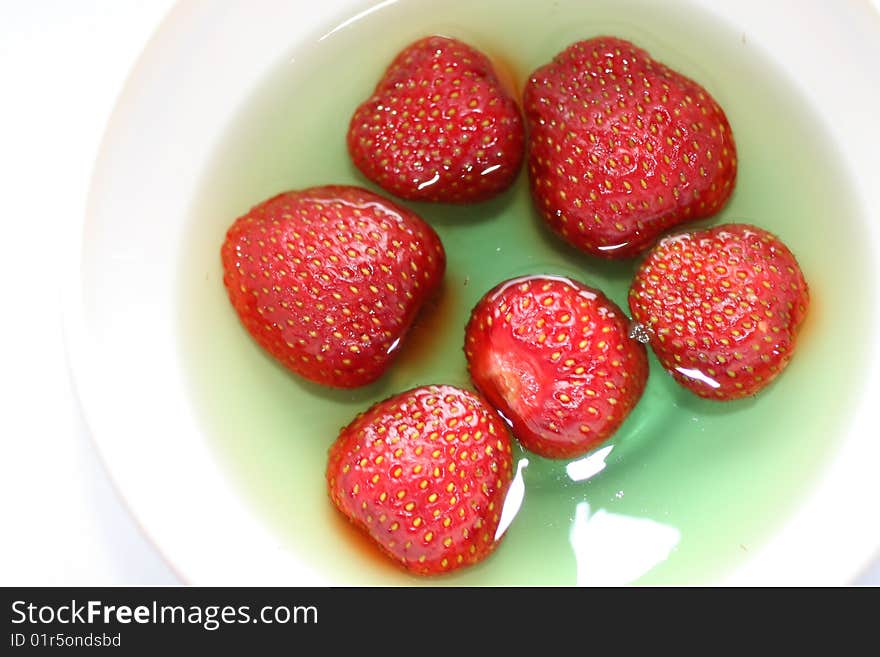 Red strawberries dessert in green jelly, homemade sweet thing