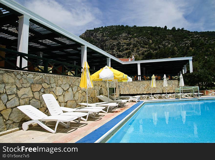 Sunbeds and umbrellas near resort's pool. Sunbeds and umbrellas near resort's pool