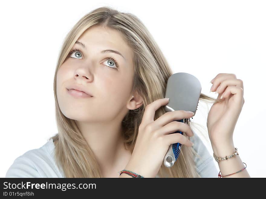 Beautiful young woman combing her hair