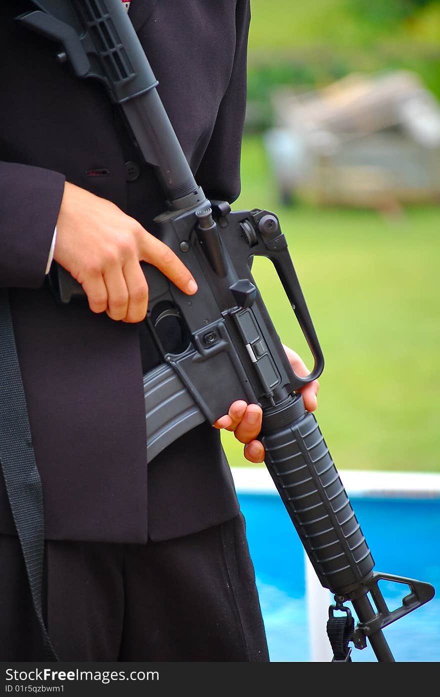 Man in a suit holding a military rifle. Man in a suit holding a military rifle