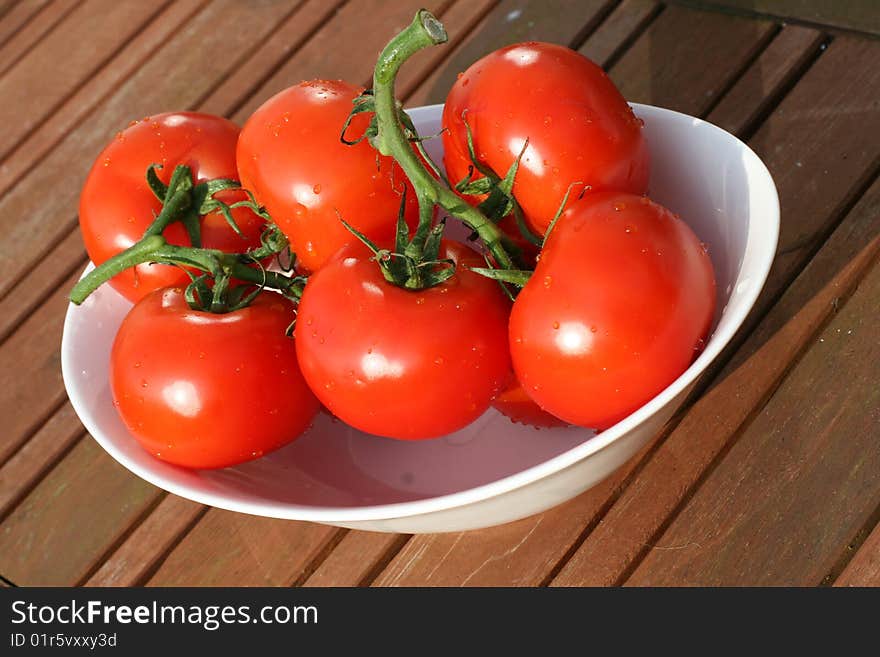 Six organic tomatoes in bowl on the garden table. Six organic tomatoes in bowl on the garden table