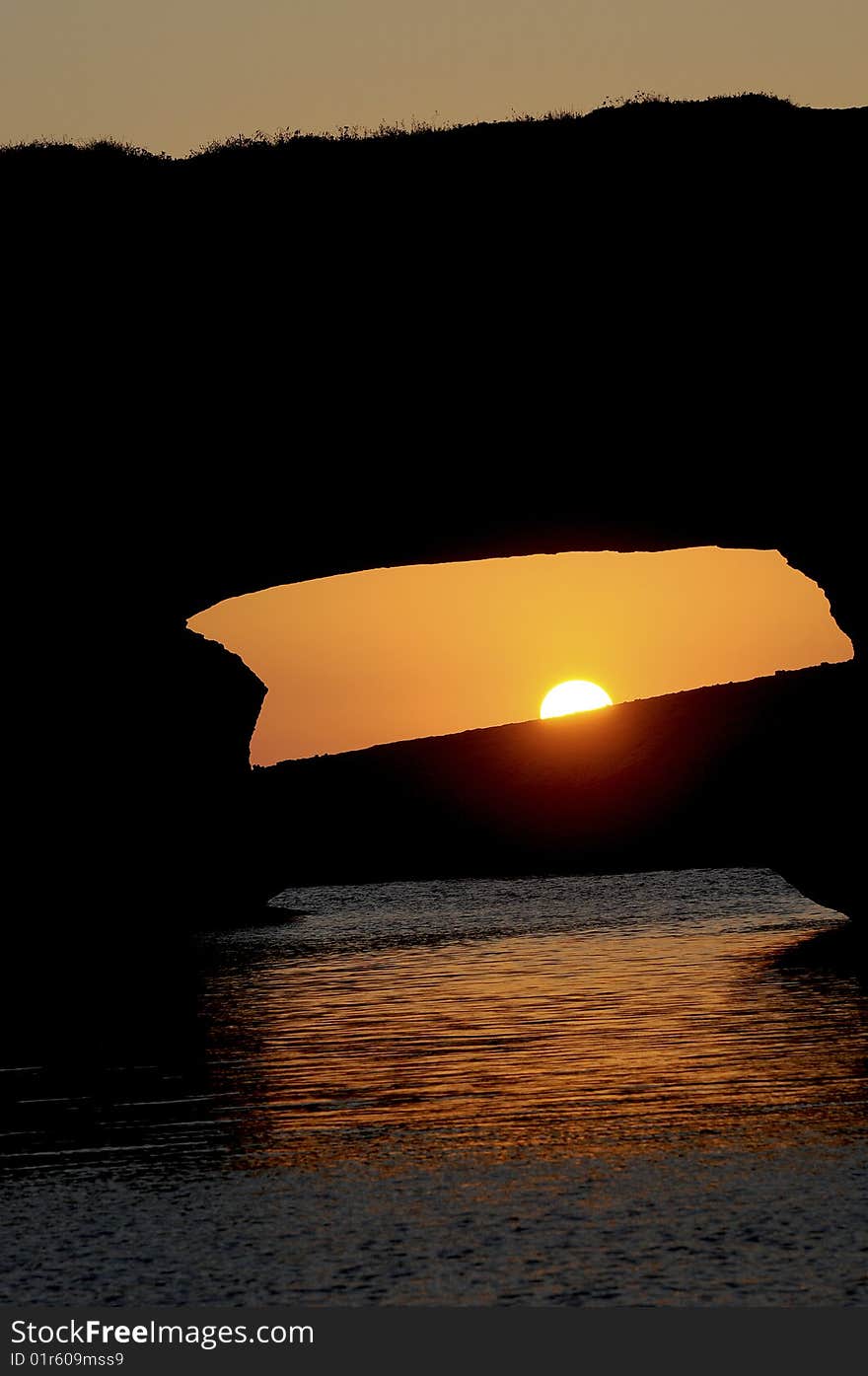 Sunset over a rocky arch on a mediterranean island. Sunset over a rocky arch on a mediterranean island